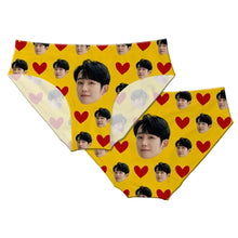 Load image into Gallery viewer, A pair of personalized panties with a printed design of a man's face surrounded by red hearts on a yellow background, displayed on a marble surface.